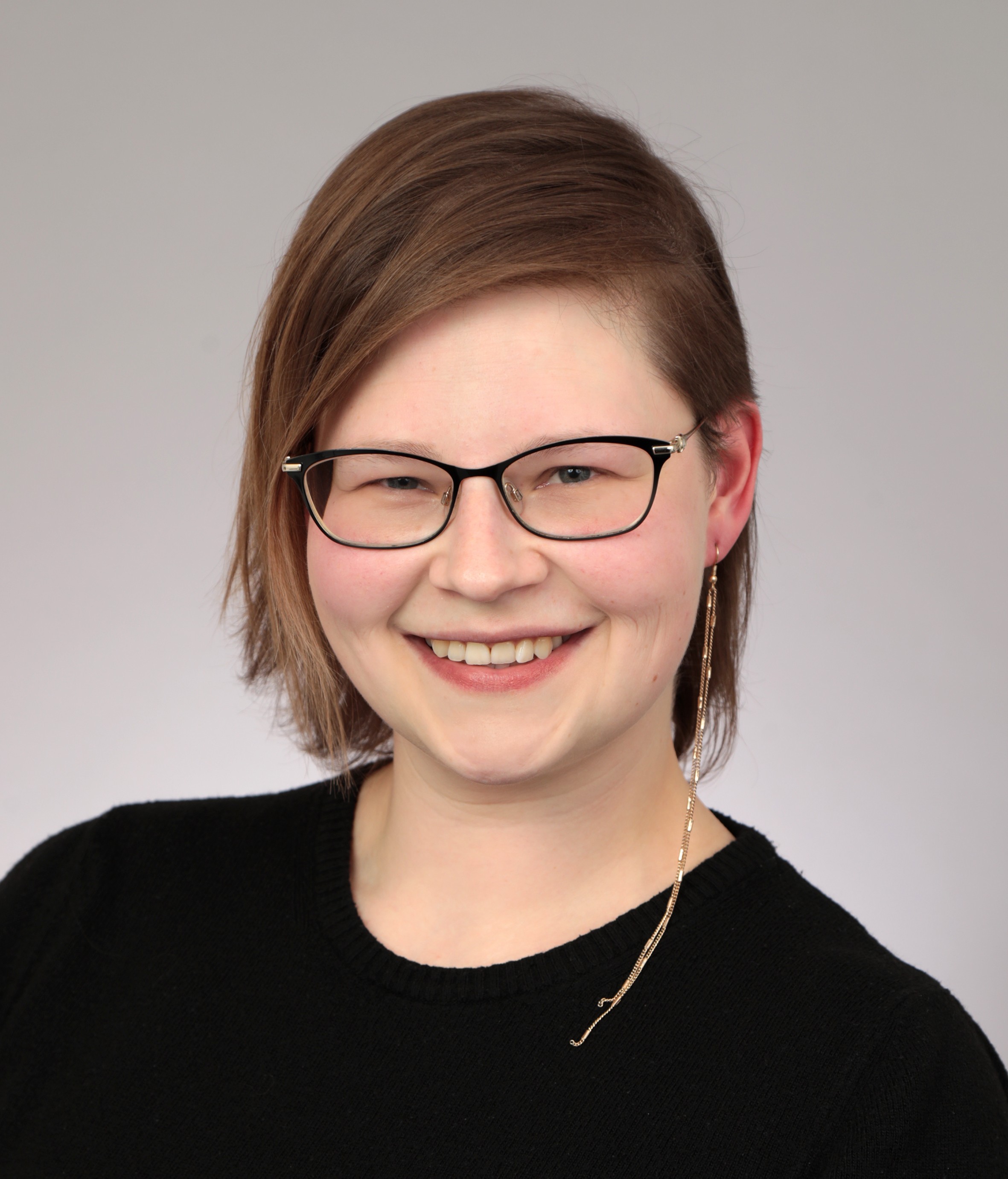 The picture shows Georgia, a 30-something woman with glasses and an undercut.